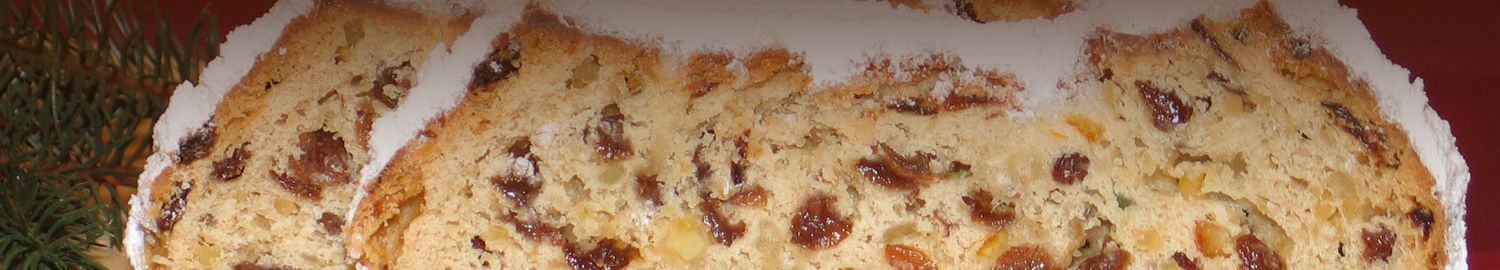 Christstollen mit Rosinen und Puderzucker, zwei Stück auf einem Holzbrett