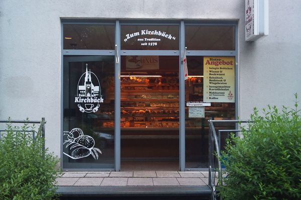 Filiale Chemnitz – Kanzlerstraße … unsere Filiale auf dem Kaßberg Gläserne Eingangstür zu Bäckerei-Filiale, im Hintergrund Theke mit Gebäck