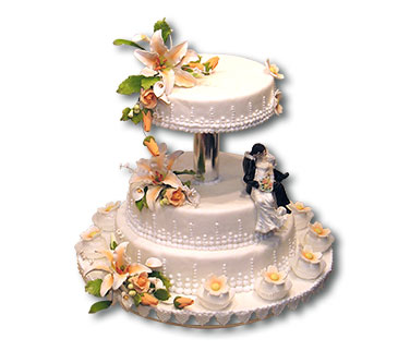 Empire – Der Charme dieser Torte ergibt sich aus dem ungewöhnlichen Zwischenraum und den Passend gestalteten Cupcakes, abgerundet wird das Bild von dem Kantenhockerbrautpaar.
