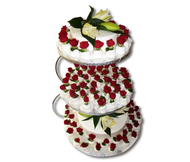 Rosenreigen – Hier sehen Sie eine Abwandlung unserer Cupcaketorte mit natürlichen Blumen. Der Gegensatz zwischen den Lilien und den roten Rosen macht diese Kombination besonders attraktiv.