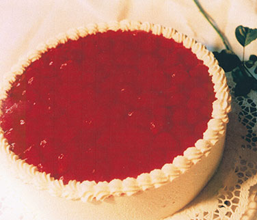 Erdbeer-Sahnetorte – Sahne mit fruchtigem Erdbeergeschmack und Erdbeerstückchen, abgerundet mit einem Spiegel frischer Erdbeeren.