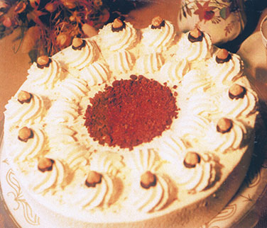Haselnusssahnetorte – Leicht geröstete Haselnussstückchen mit gesüßter Sahne auf lockeren Bisquitböden geben der Torte ihren unverwechselbare 